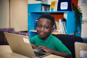 A picture of a student at a Hales Valley Trust school working on a laptop.